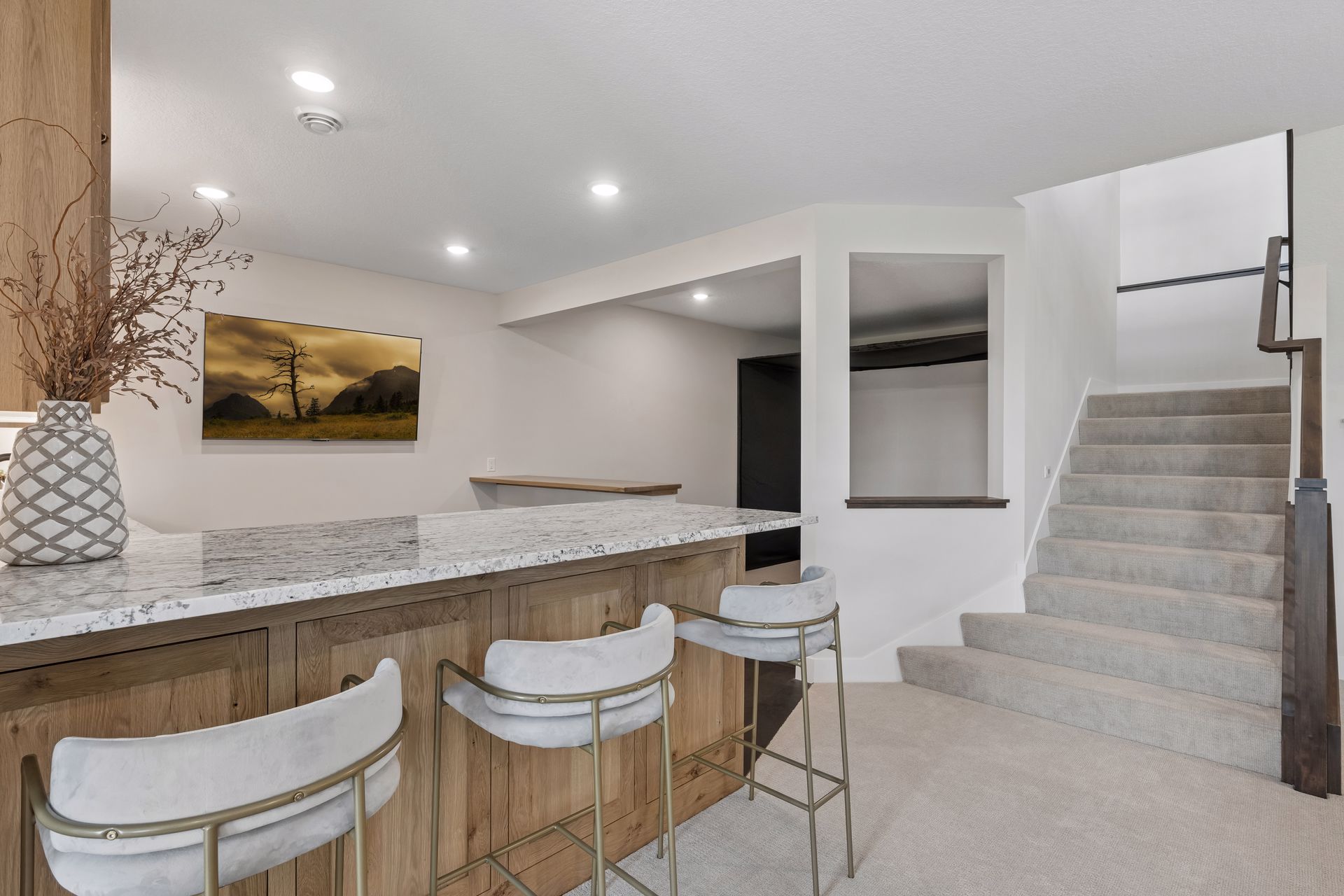 Lower level wet bar with custom cabinetry, beverage refrigerator and serving area